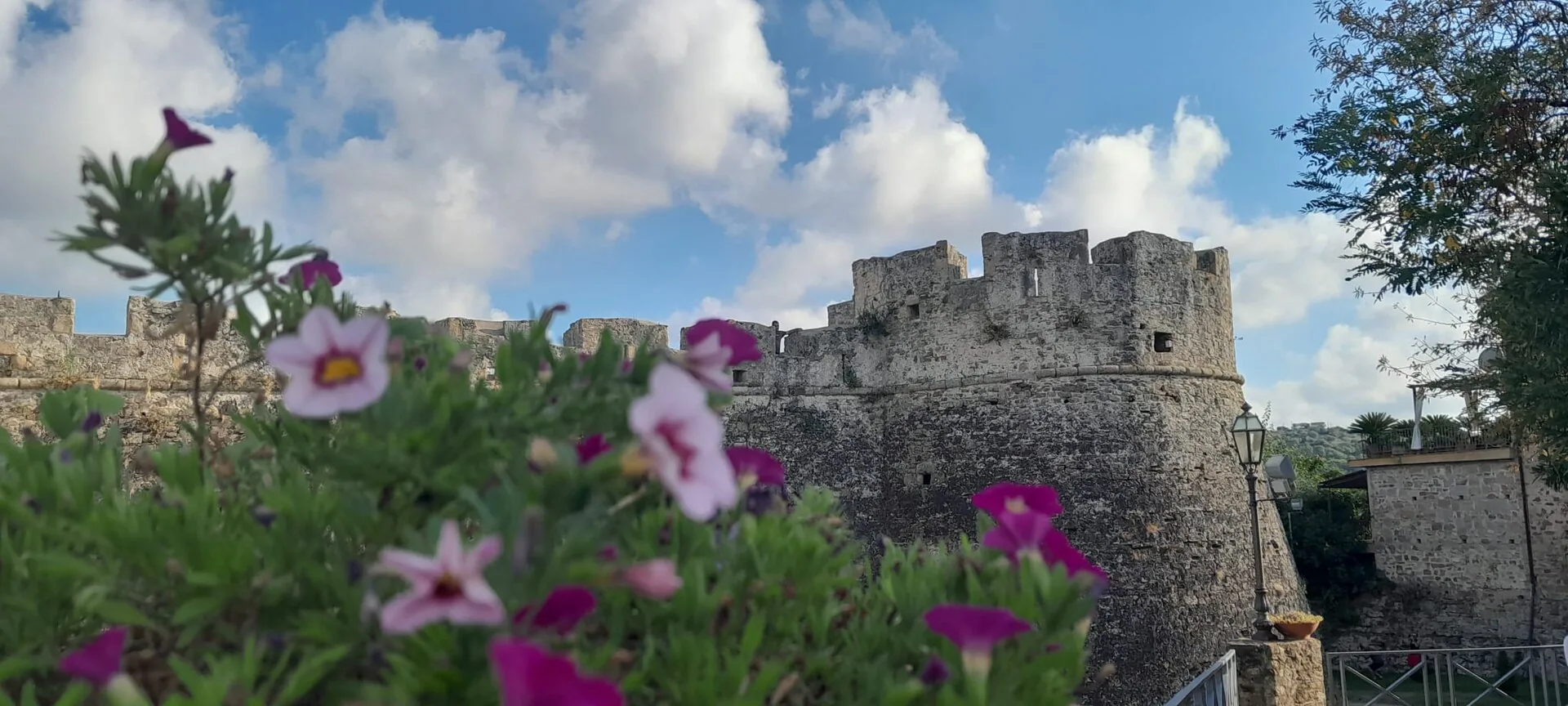 Il Castello Angioino-Aragonese di Agropoli, con le mura in pietra e i fiori in primo piano