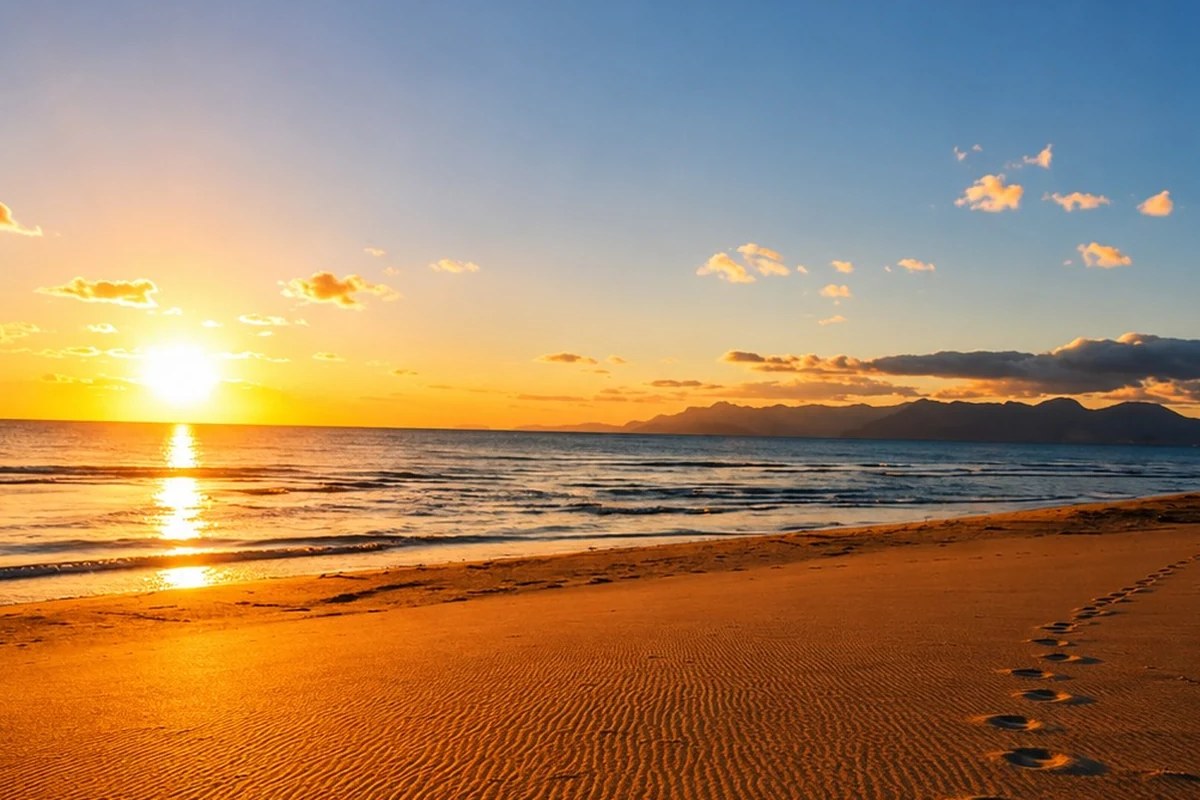 Tramonto sulla spiaggia davanti a Pietra Marina, con il mare calmo e il cielo azzurro