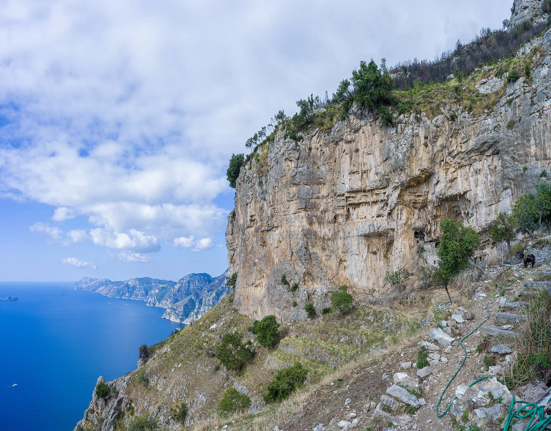 Panorama dal Sentiero degli Dei sulla Costiera Amalfitana, con pareti rocciose a picco sul mare blu